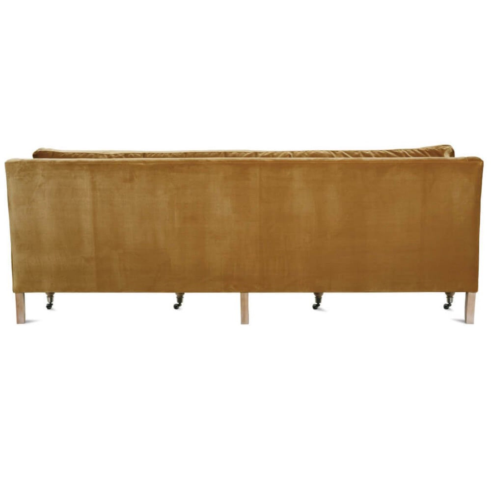 Back view of a Madeline sofa in antiqued amber velvet with light wood legs and caster wheels on a white background.