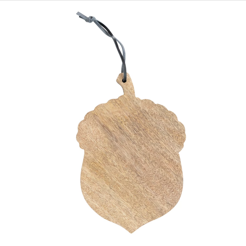 An acorn-shaped natural wood cutting board with a dark leather hanging tie at the top.