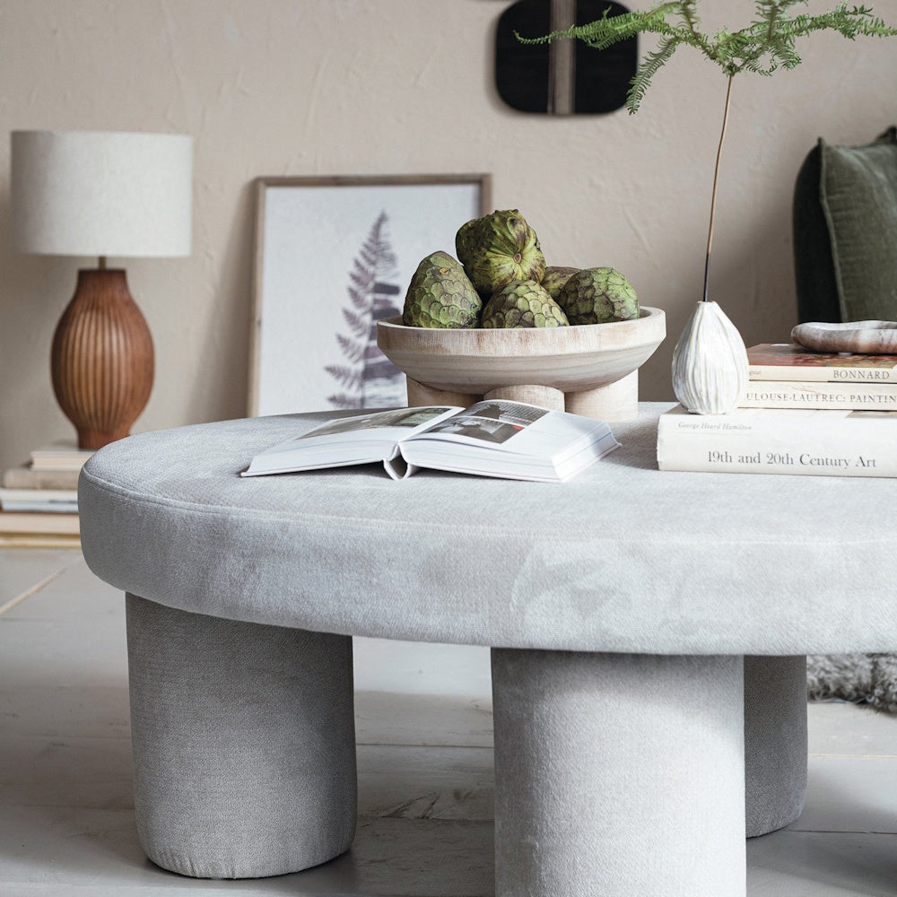 Mango wood table lamp with vertical carved lines and a neutral fabric shade styled on a surface in a cozy room setting.