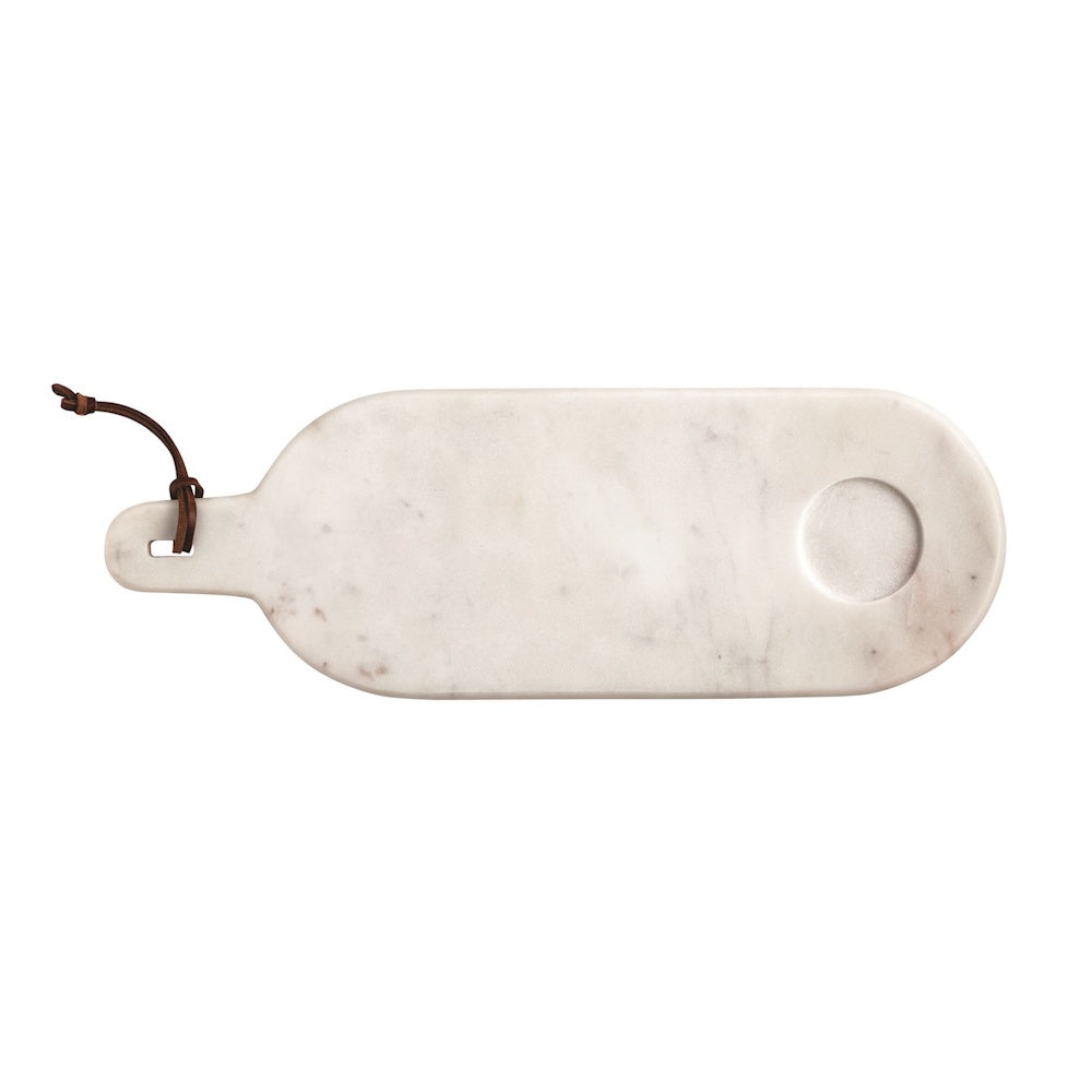 White marble serving board with handle and leather loop, featuring a circular indentation for decorative sitters.