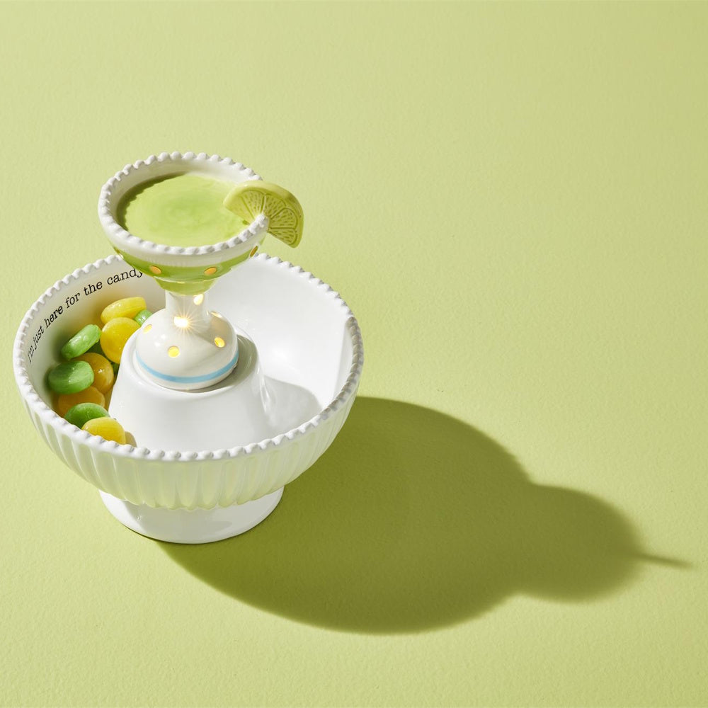 Ceramic margarita light-up sitter in a white candy bowl with lime candies, for home decor and party hosting.