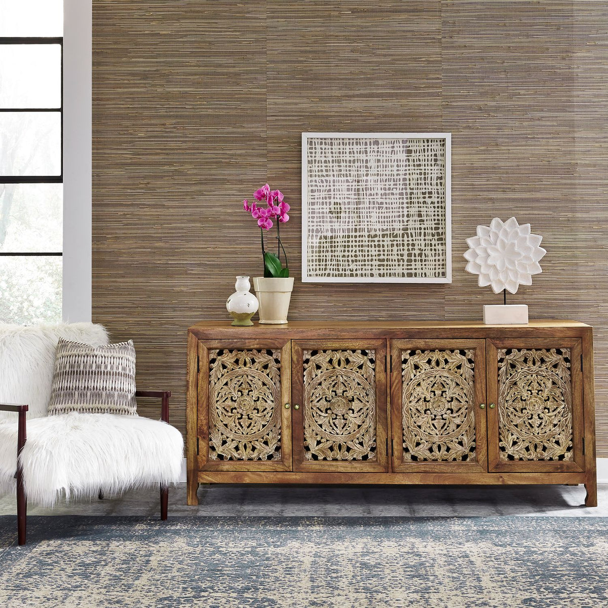Carved mango wood 4 door TV stand styled in living room with floral panels and natural brown finish.