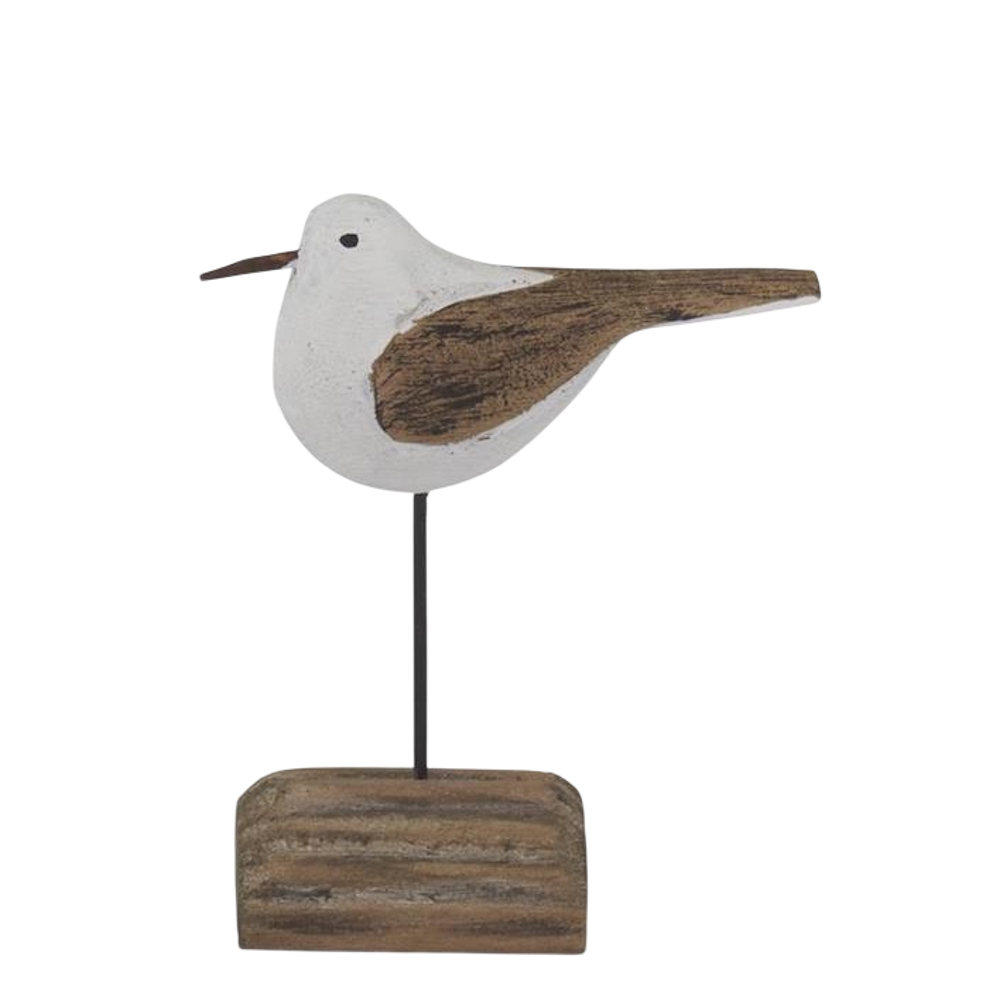 Handcrafted wooden seagull figurine on a driftwood base, nautical beach house decor on white background.