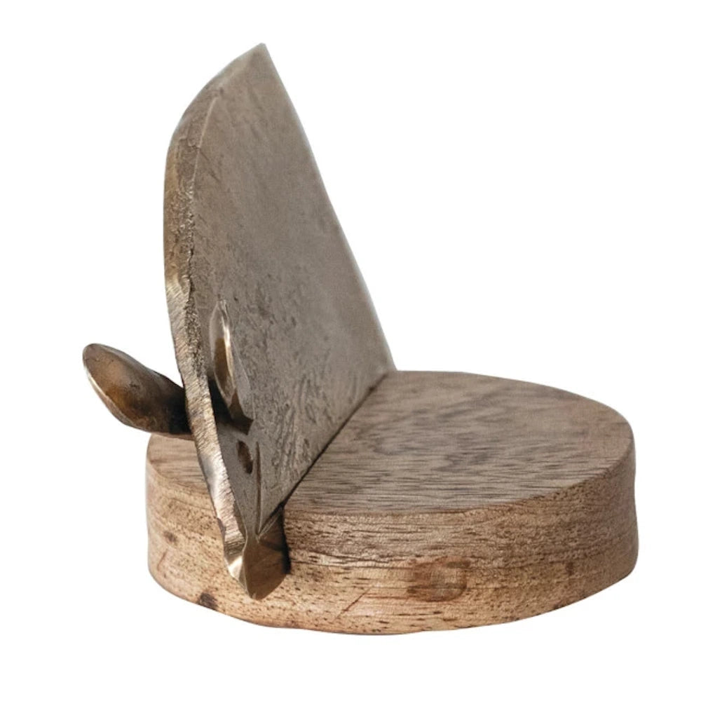 Metal mouse-shaped cheese knife with a curved blade resting on a round mango wood base for rustic kitchen decor.