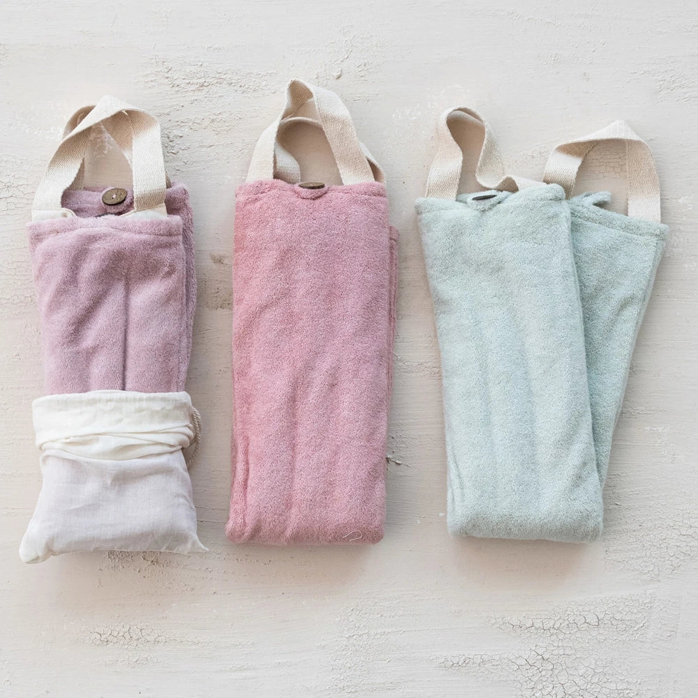 Three soft fabric hot-cold neck wraps in mauve, rose, and sage green with handles. Microwavable therapy packs.