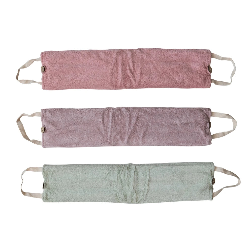 Three microwaveable hot and cold neck wraps in pink, purple, and green textured fabric with handles and buttons.