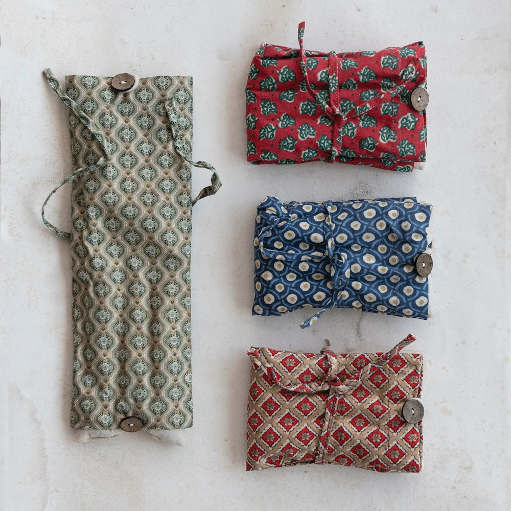 Microwaveable hot and cold packs in assorted patterned cotton covers with button closures.