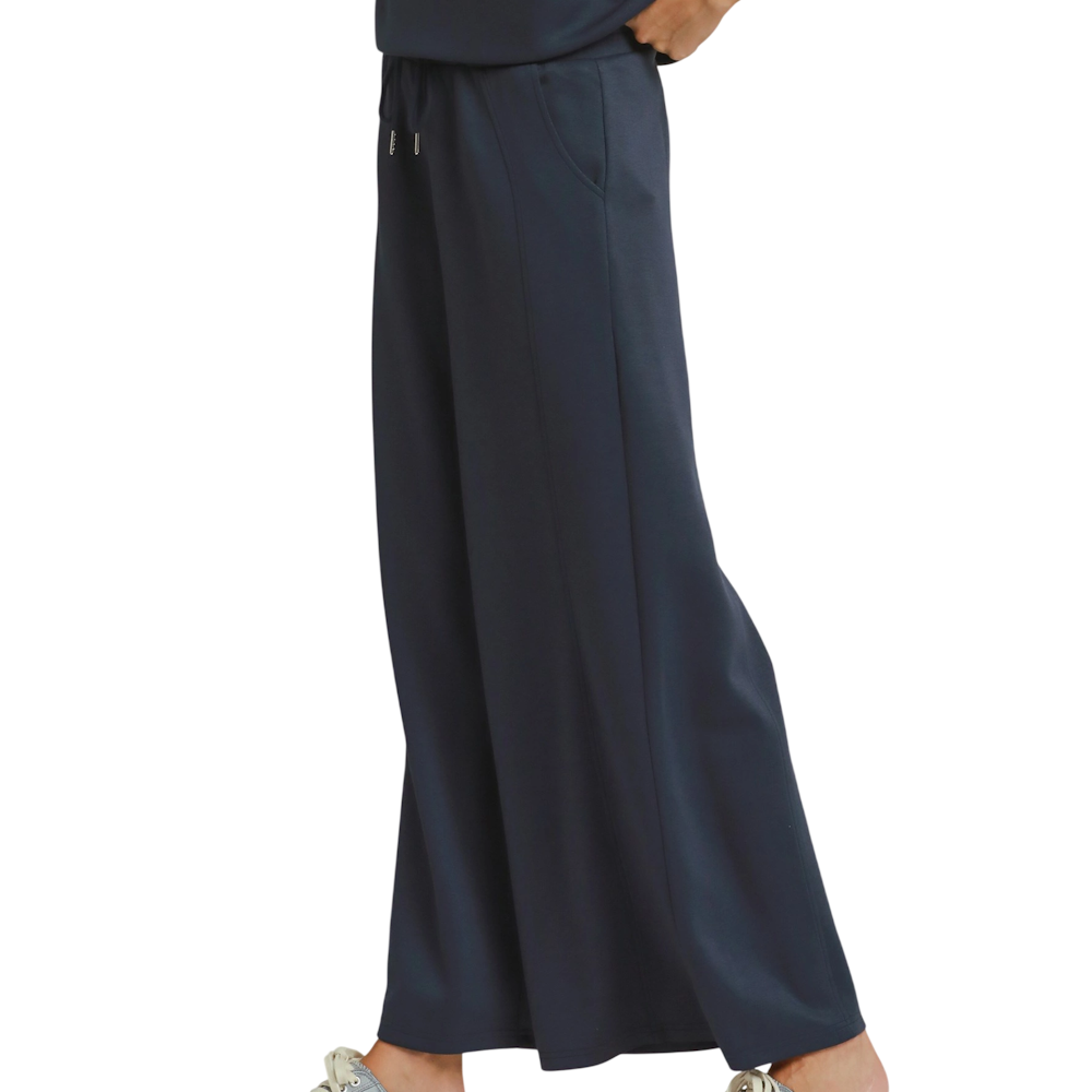 Side view of dark navy wide-leg knit pants with an elastic drawstring waist and side pockets.