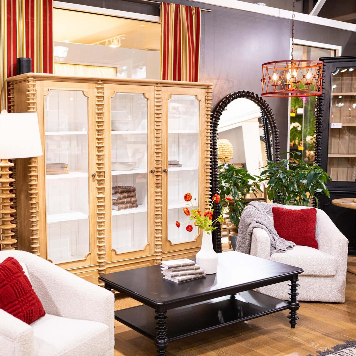 Modern living room furniture with a light wood display cabinet, black coffee table, and white armchairs.