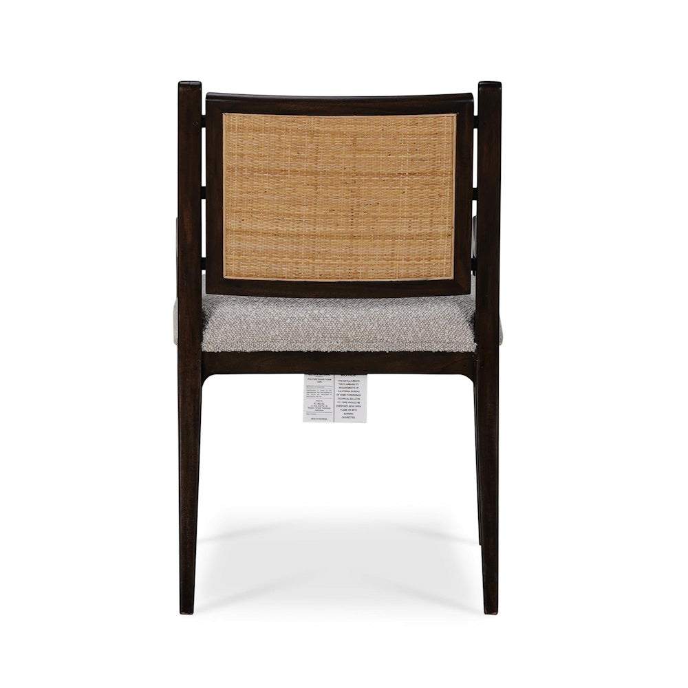 Back view of a dark wood dining chair featuring a woven cane backrest and textured upholstered seat.