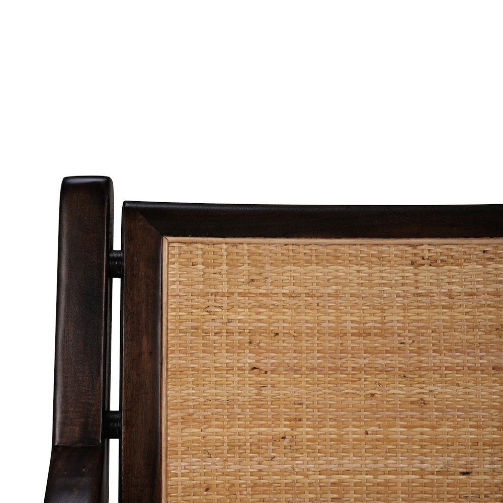 Close-up of a woven rattan backrest on a dark wood dining chair frame.