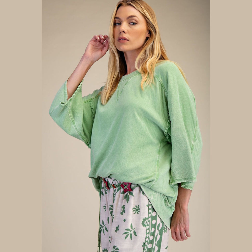 Woman wearing a light green mineral-washed cotton gauze boxy top with wide sleeves and a relaxed fit.