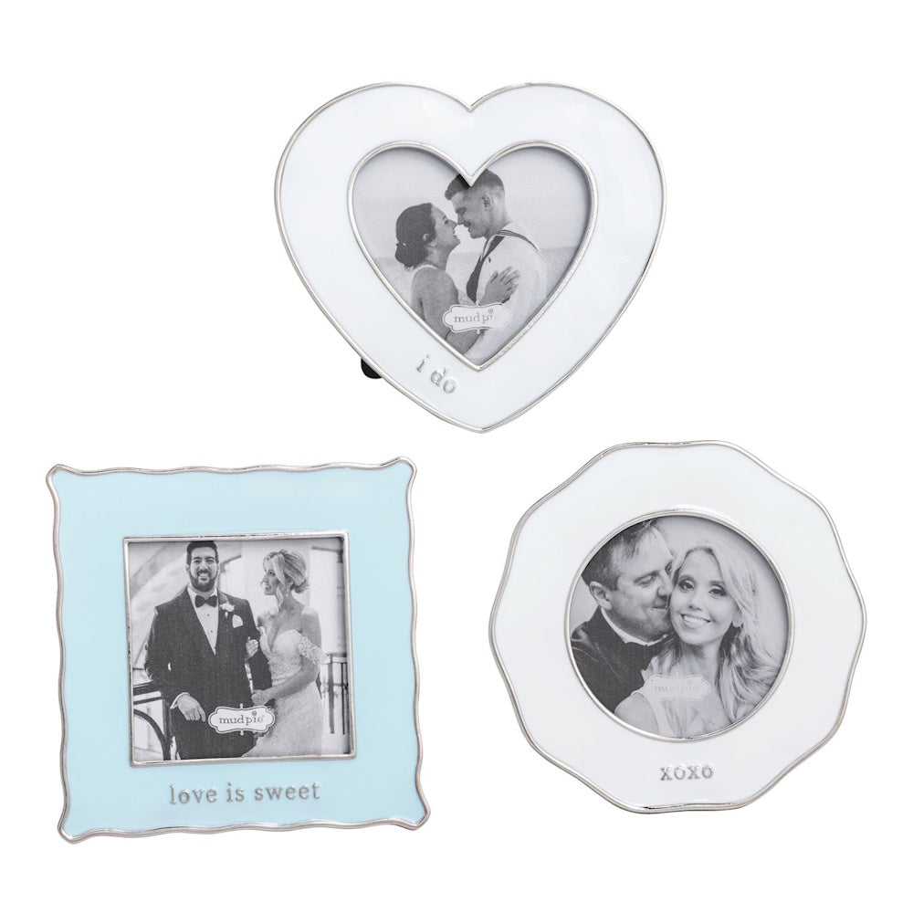 Three mini enamel wedding frames in heart, scalloped, and square shapes with black and white couple photos.