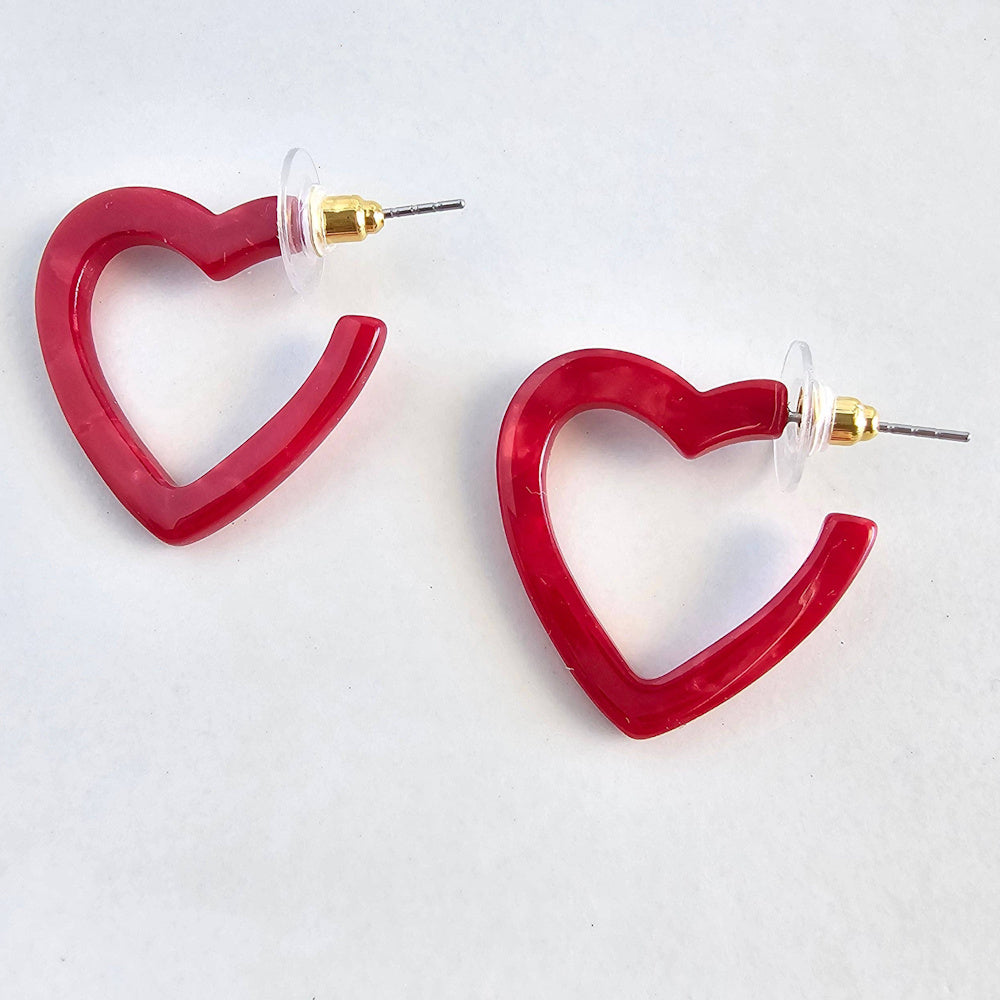 Pair of mini red heart-shaped resin hoop earrings with gold-plated posts and clear plastic disc backings.