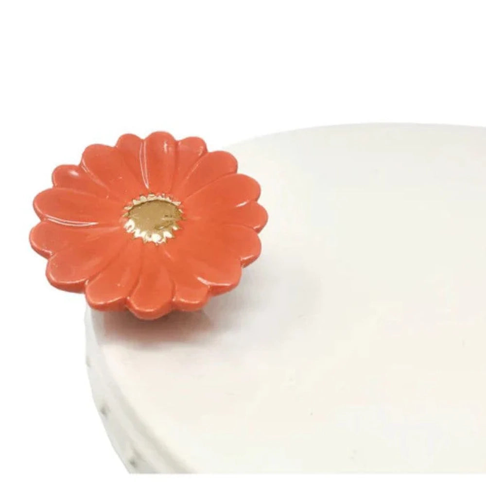 Mini orange gerbera daisy ceramic attachment mounted on a white platter edge.