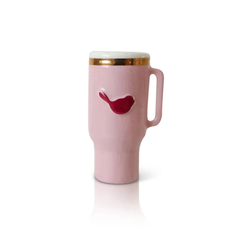Pink ceramic travel mug with a gold rim and a red bird emblem on a white background.