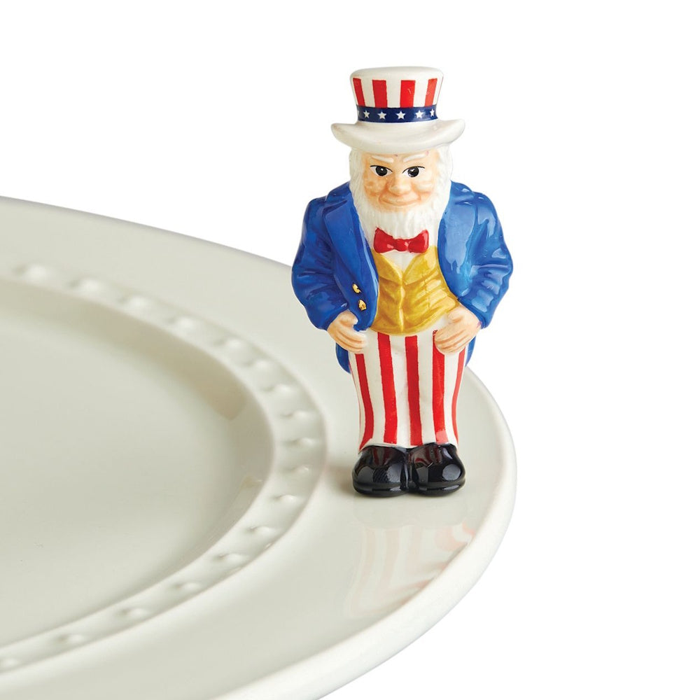 A ceramic Uncle Sam figurine attached to the rim of a white serving platter.