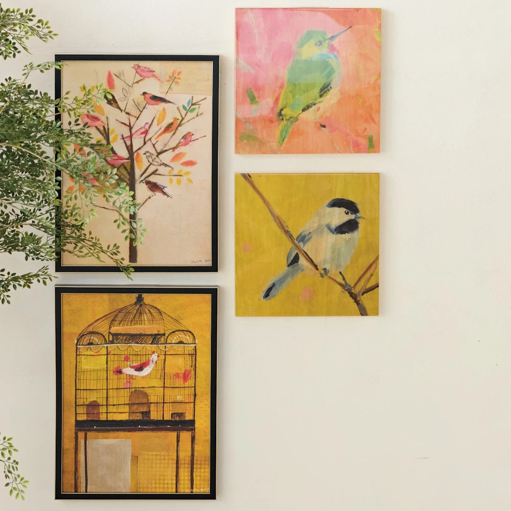 Bird-themed wall art gallery with framed sketches and colorful canvas paintings of birds, branches, and a vintage cage.