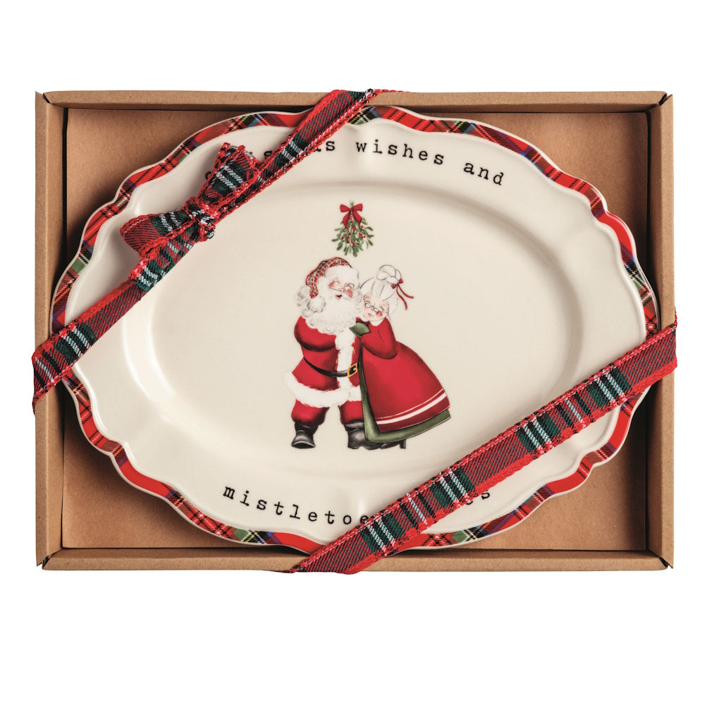 Oval Christmas sentiment plate in a gift box with Mr. and Mrs. Claus under mistletoe and text.
