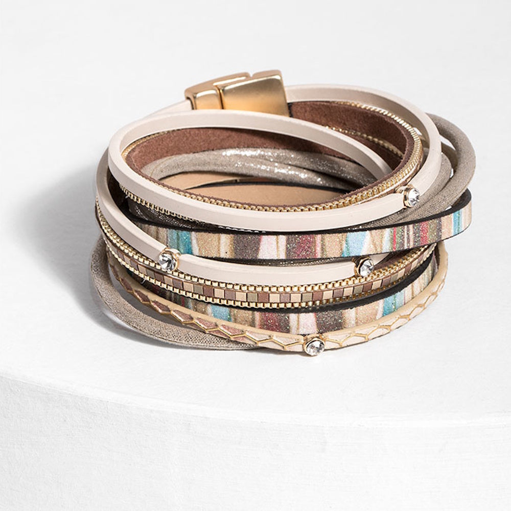 Multi-layered wrap bracelet with beige, gold, and patterned strands, rhinestone accents, and a magnetic clasp.