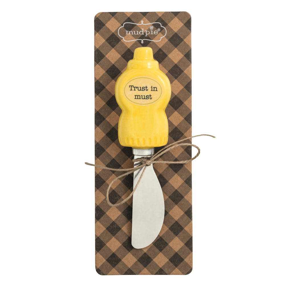 Mud Pie mustard bottle spreader with "Trust in must" text on a brown checkered gift card background.