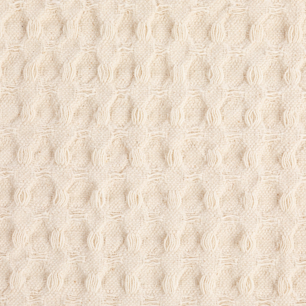 Close-up texture of the natural stonewashed cotton waffle weave tea towel.