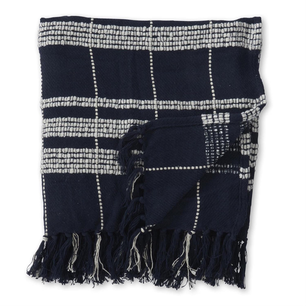 Folded navy blue throw blanket with textured cream grid pattern and fringed edges.