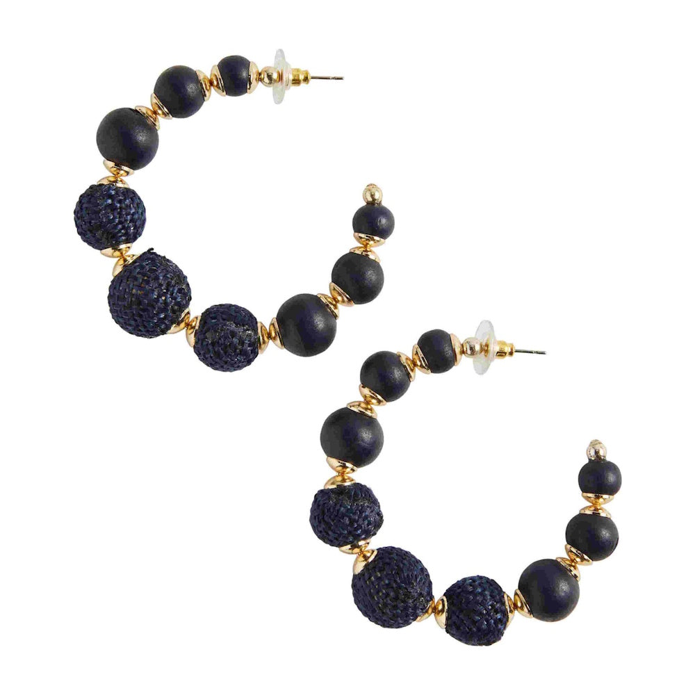A pair of large hoop earrings made of textured dark blue and smooth black beads with gold accents.
