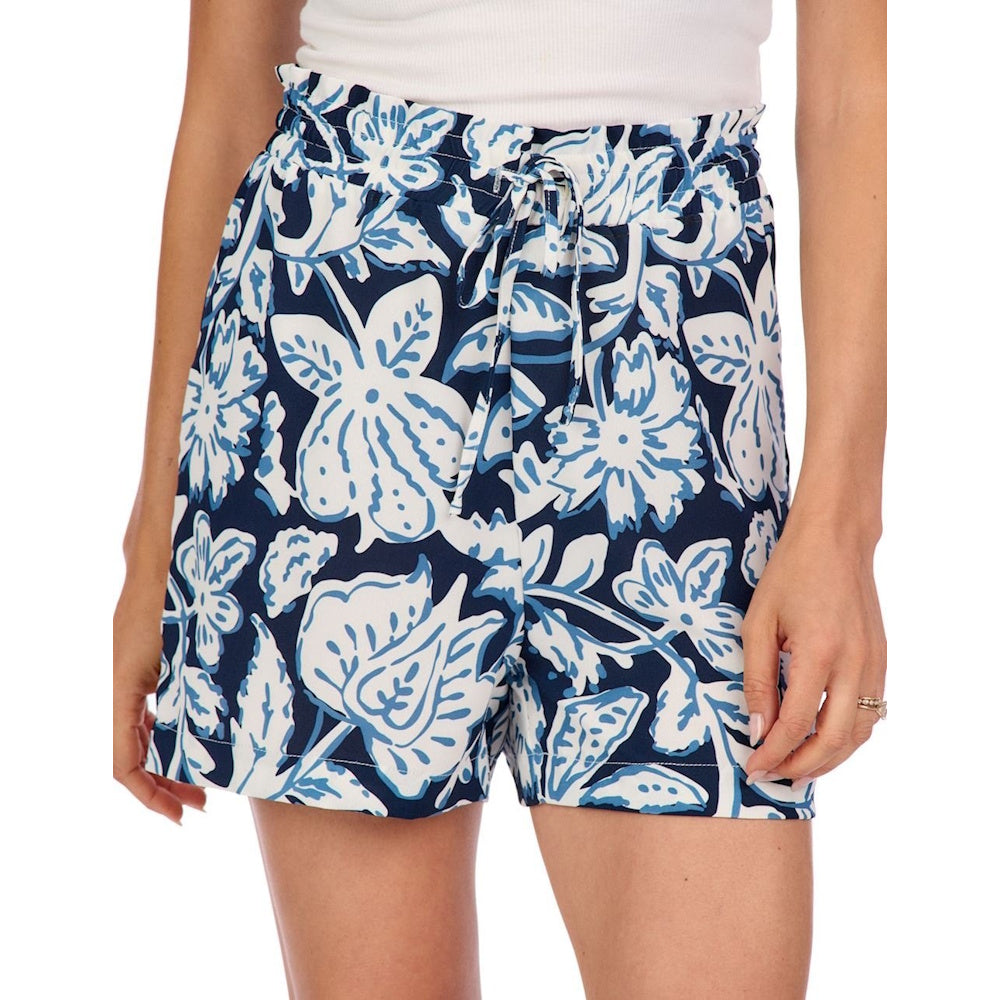 A person wearing blue and white floral patterned shorts with a paperbag waist and a drawstring.