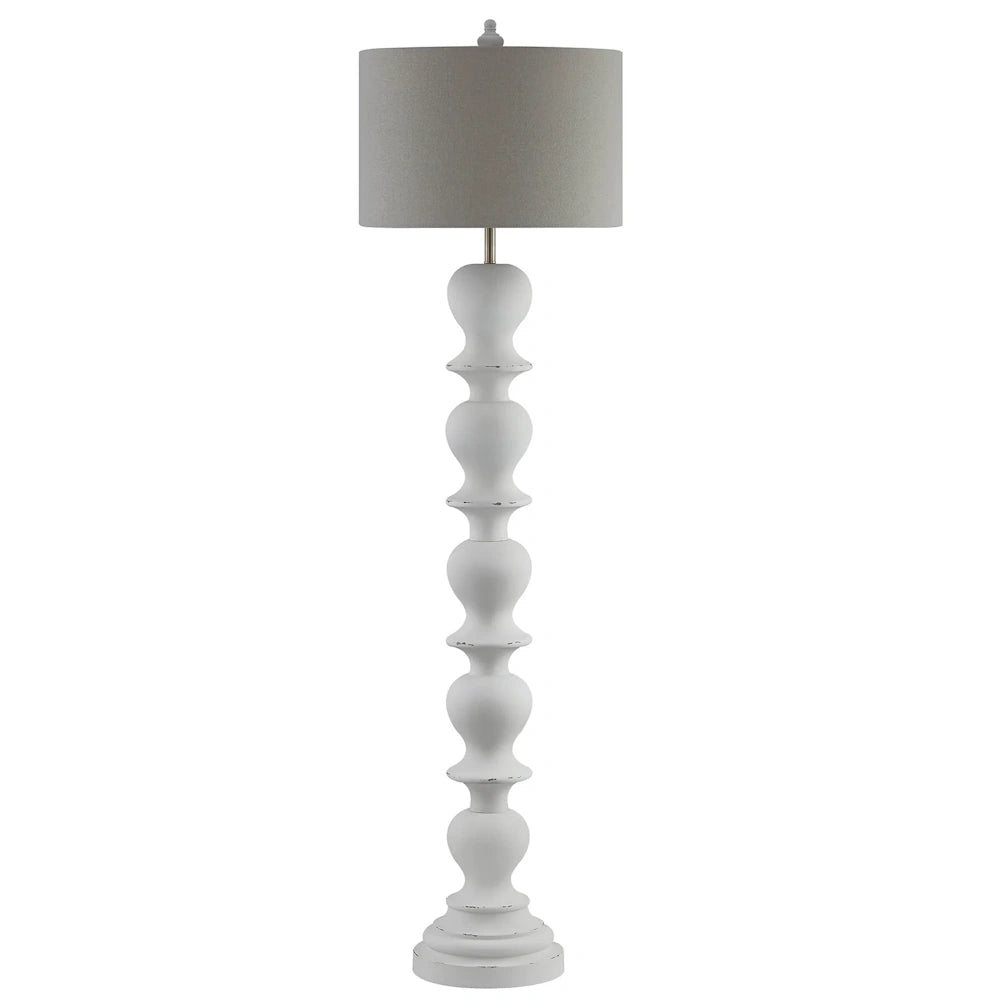 White distressed floor lamp with turned spindle style base, brushed metal accents and light gray drum shade.