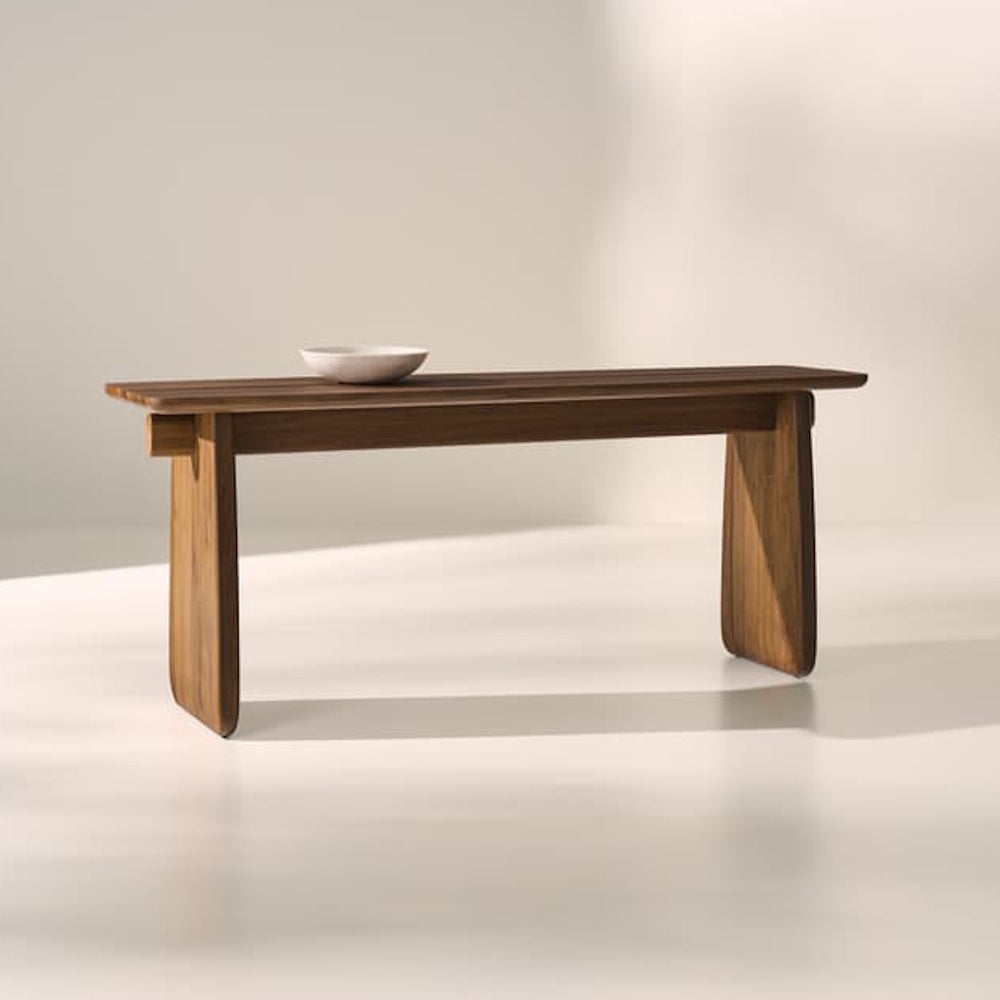 Modern walnut console table styled in a minimalist interior, showcasing clean lines and sculptural panel legs.