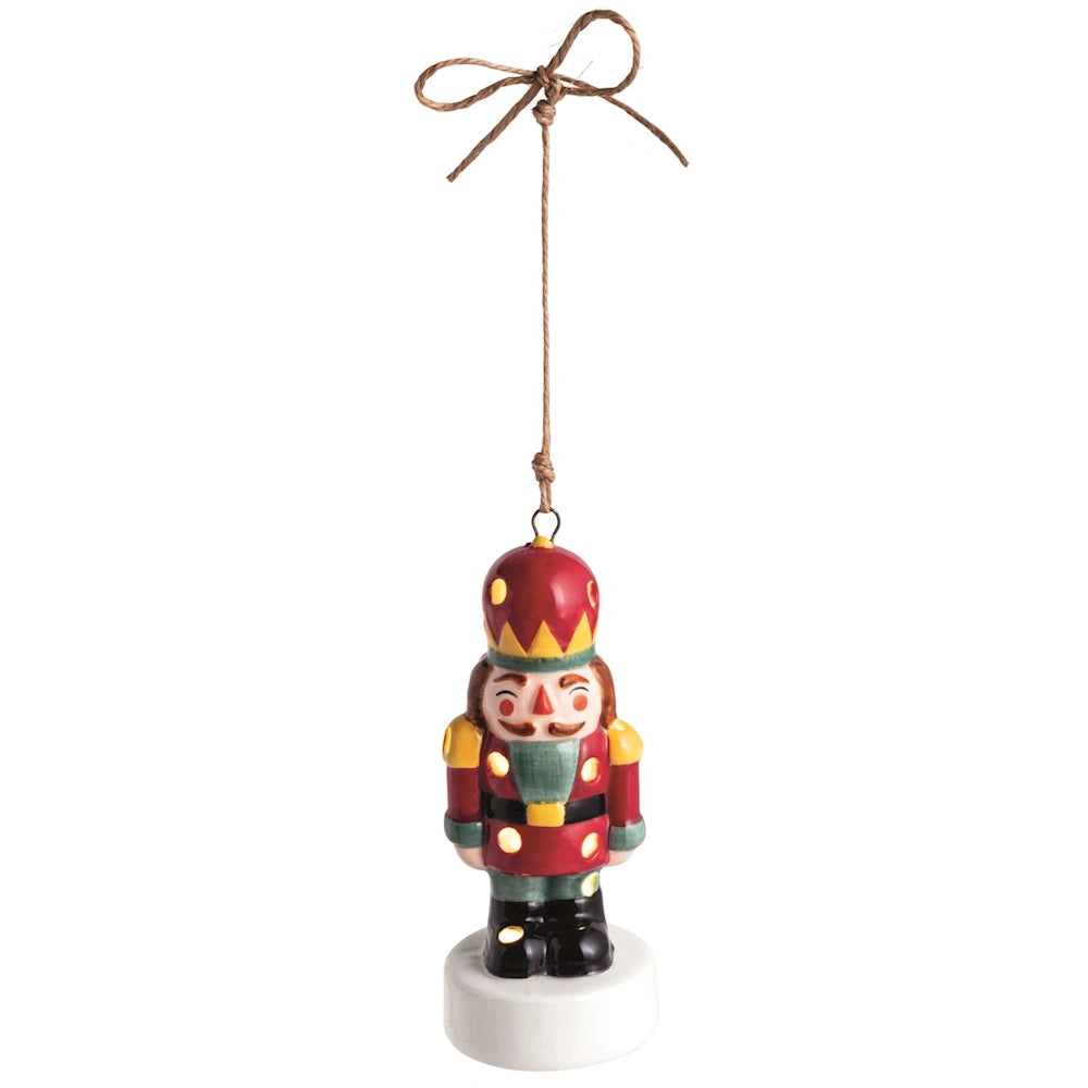 Ceramic LED nutcracker ornament suspended by a twine bow.