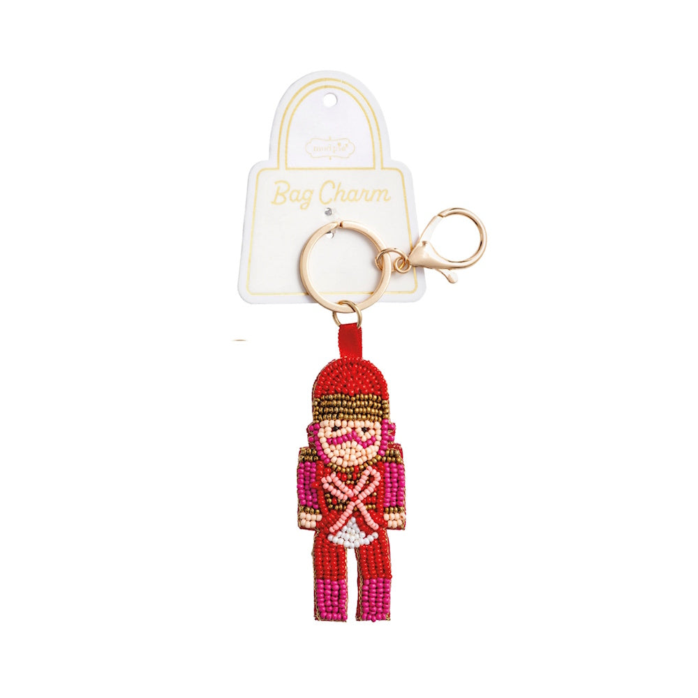 Beaded nutcracker bag charm in red and pink with a gold keyring and clasp attachment.