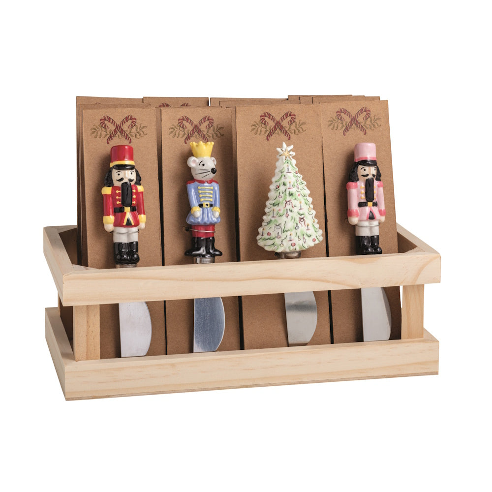 Wooden display crate filled with assorted Christmas spreaders featuring nutcrackers, a mouse king, and a tree.