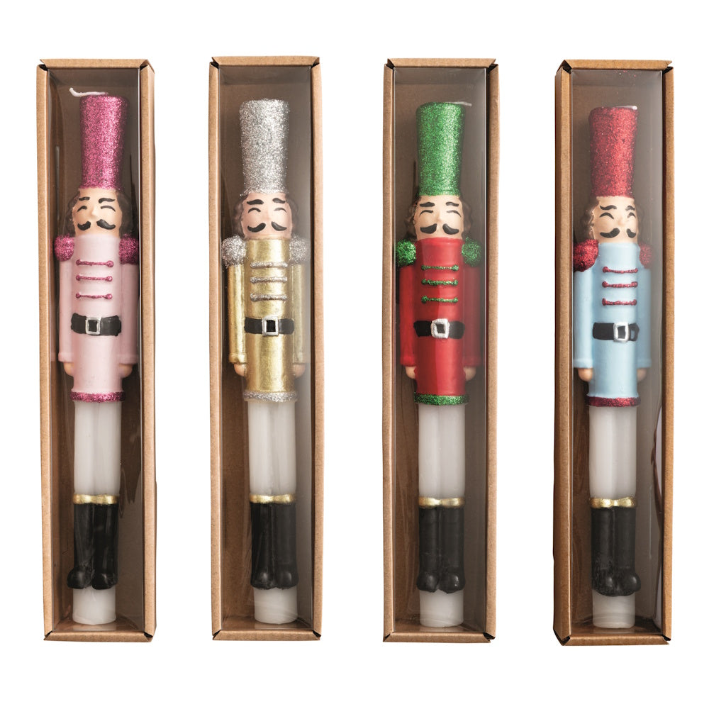 Front view of a cardboard retail display box filled with assorted wax nutcracker taper candles.