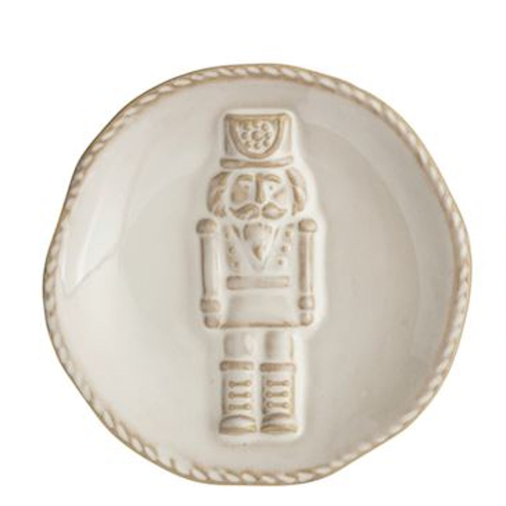 Small white ceramic tidbit plate featuring an embossed nutcracker figure in the center.