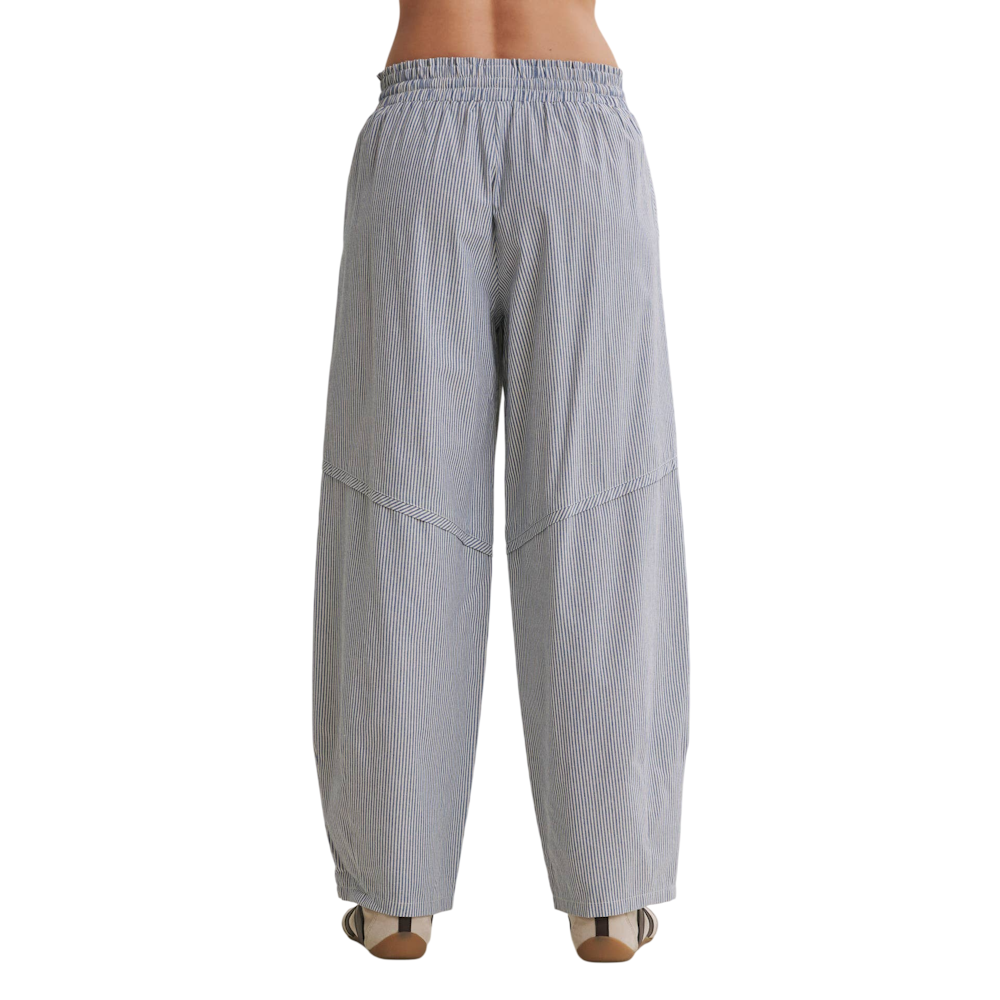 Back view of blue and white vertical striped barrel pants with an elastic waistband and relaxed fit.