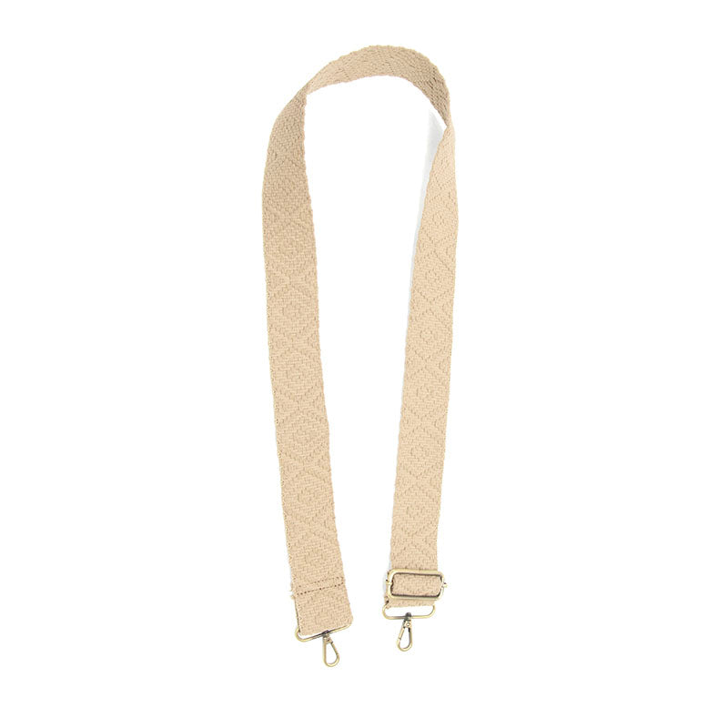 Off-white woven guitar strap with a geometric diamond pattern, adjustable slider, and antique brass lobster clasps.