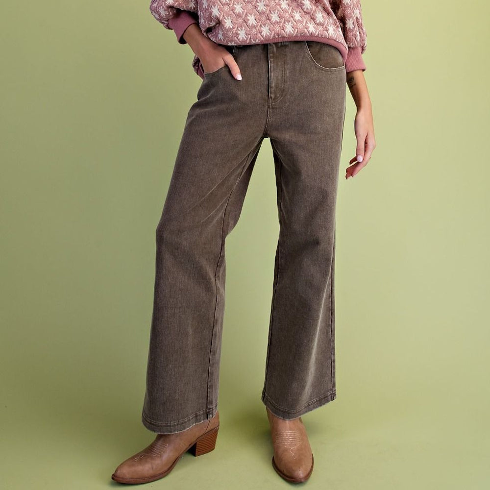 Person wearing olive green washed wide-leg twill pants with light brown cowboy boots.