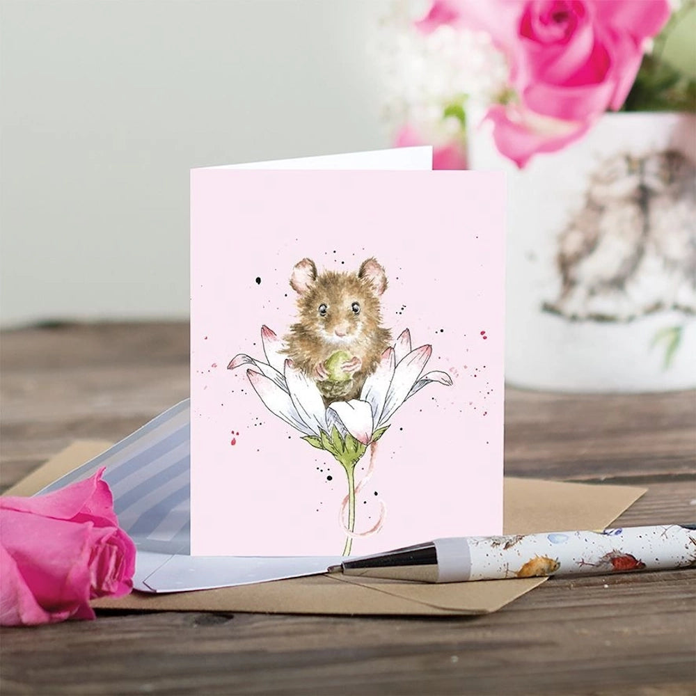 Watercolor illustration of a small brown mouse sitting inside a white daisy on a pink gift enclosure card.