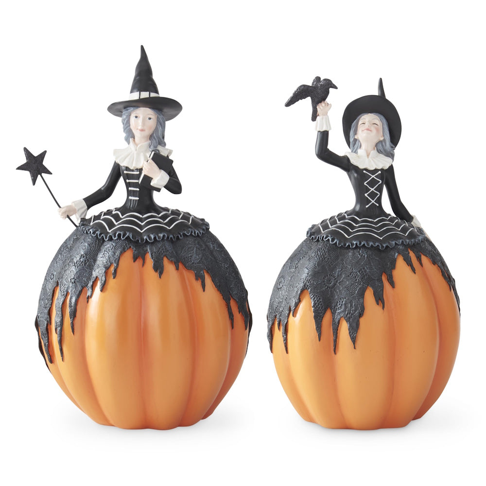 Two witch figurines with pumpkin lower bodies wearing black dresses, holding a star wand and raven.