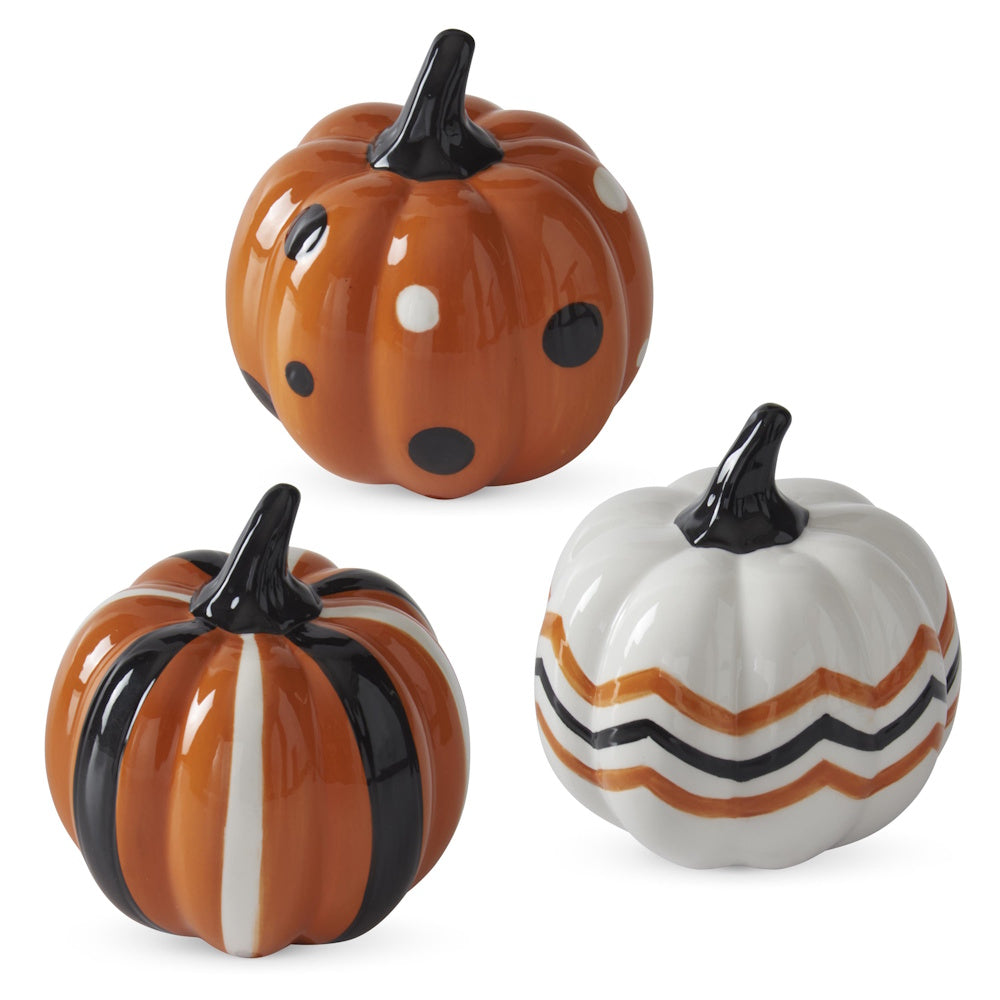 Set of three glossy ceramic pumpkins with polka dot, striped, and chevron patterns in orange, white, and black.