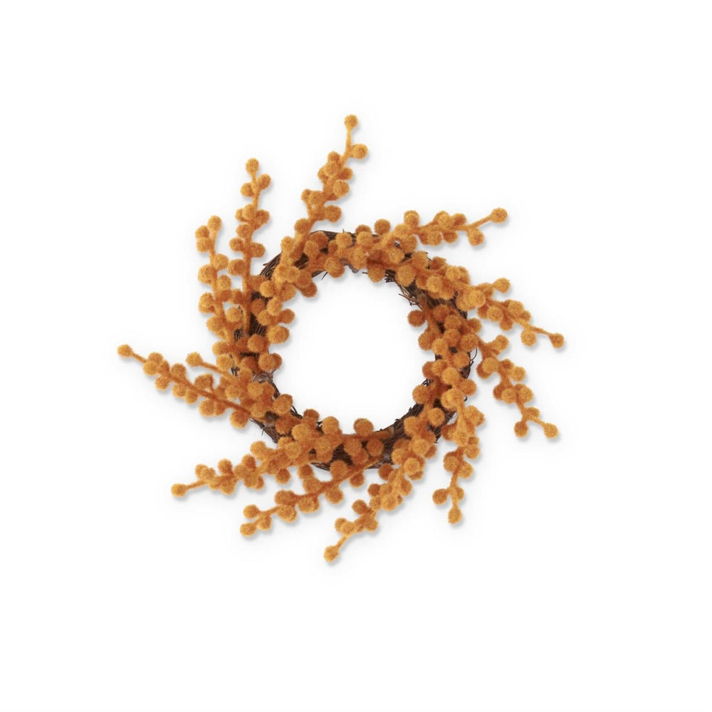 A small wreath or candle ring made of a brown twig base and fuzzy, orange flocked berry stems.