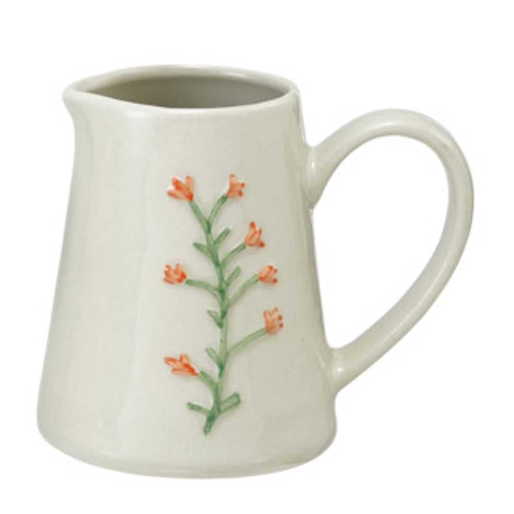 Stoneware creamer featuring an embossed orange botanical floral design.