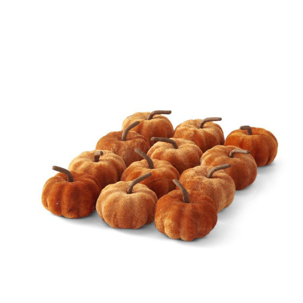Set of mini orange velvet pumpkins with brown stems for autumn and Thanksgiving table decor.