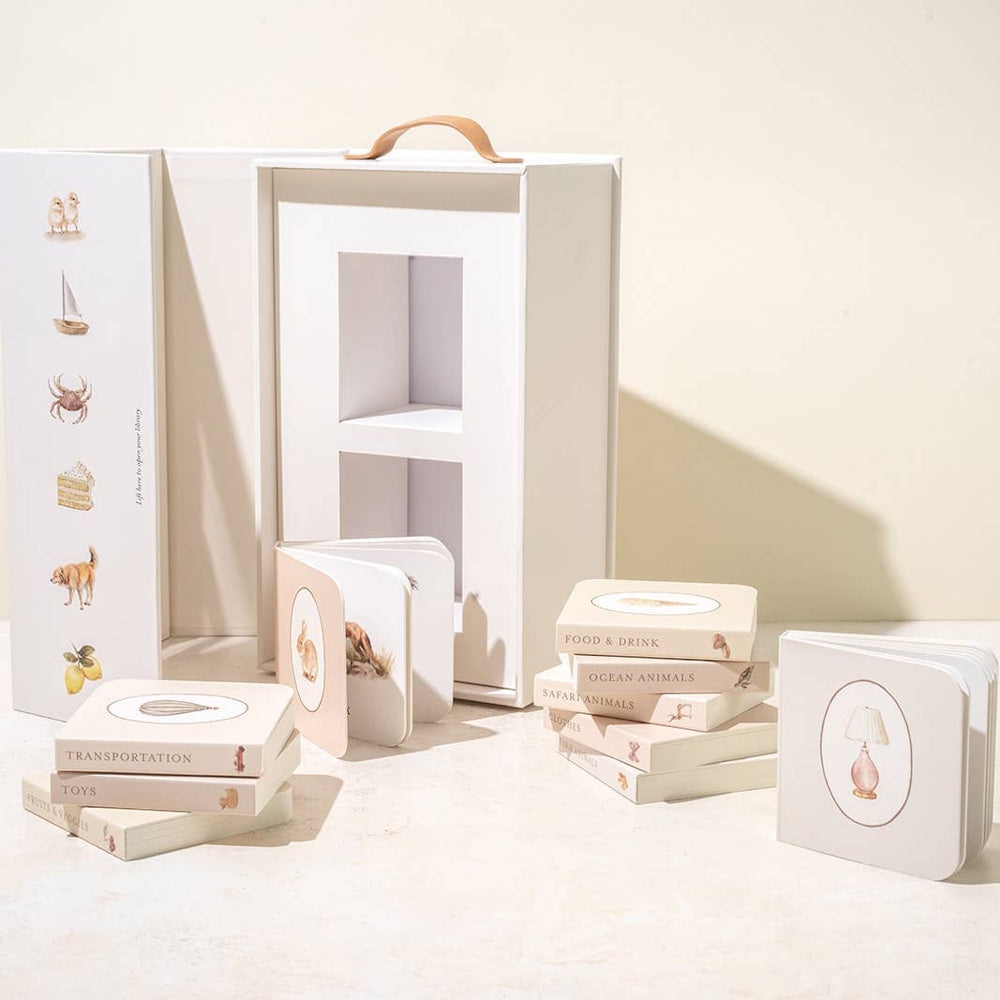 Our Very Little Library board book set in a white carrying case with minimalist animal and object illustrations.