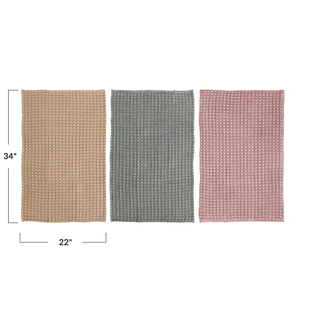 Three 22x34 inch oversized waffle weave tea towels in tan, sage, and dusty rose laid flat to show dimensions and texture.