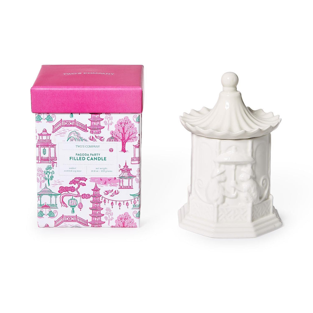 White pagoda-shaped ceramic candle jar next to its pink patterned gift box.