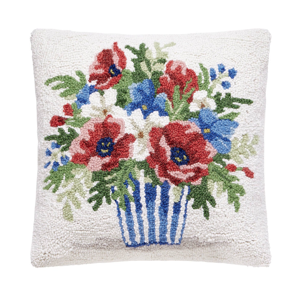 Hand-hooked throw pillow featuring red poppies and blue flowers in a striped patriotic vase on a cream background.