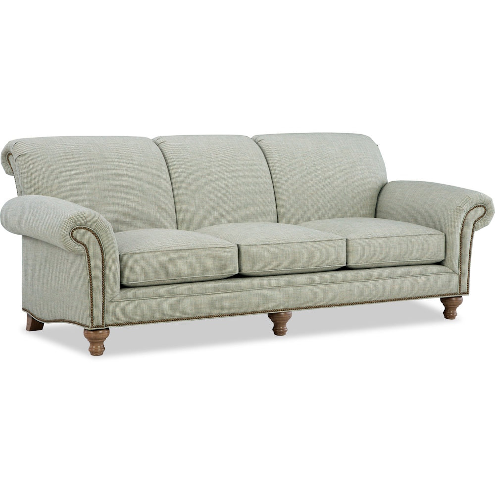 Light green traditional three-cushion sofa with rolled arms, nailhead trim, and turned wooden feet.